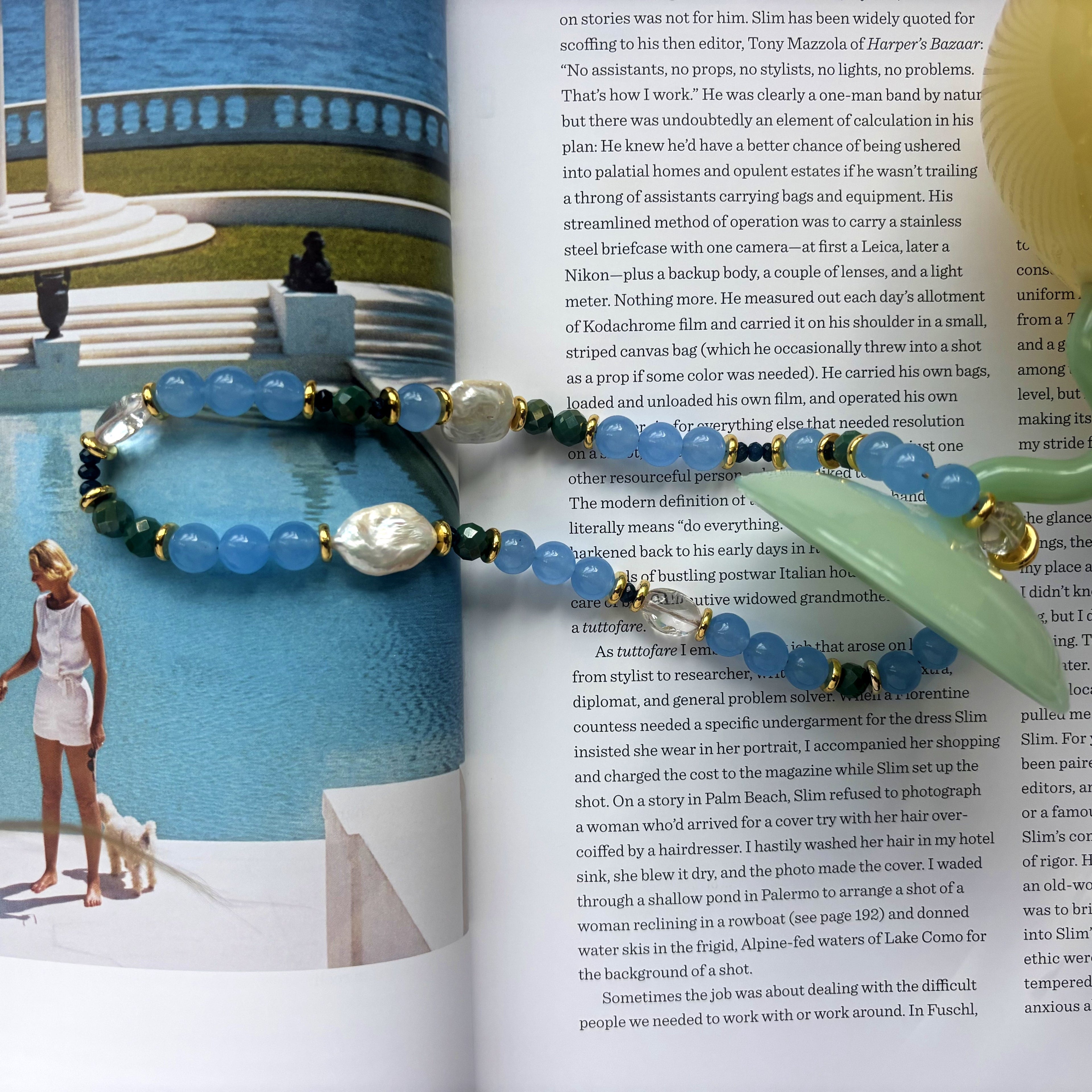 Beaded necklace with blue and green beads on a magazine page